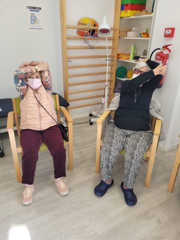 Imagen de dos personas mayores realizando estiramientos después de realizar ejercicio físico.